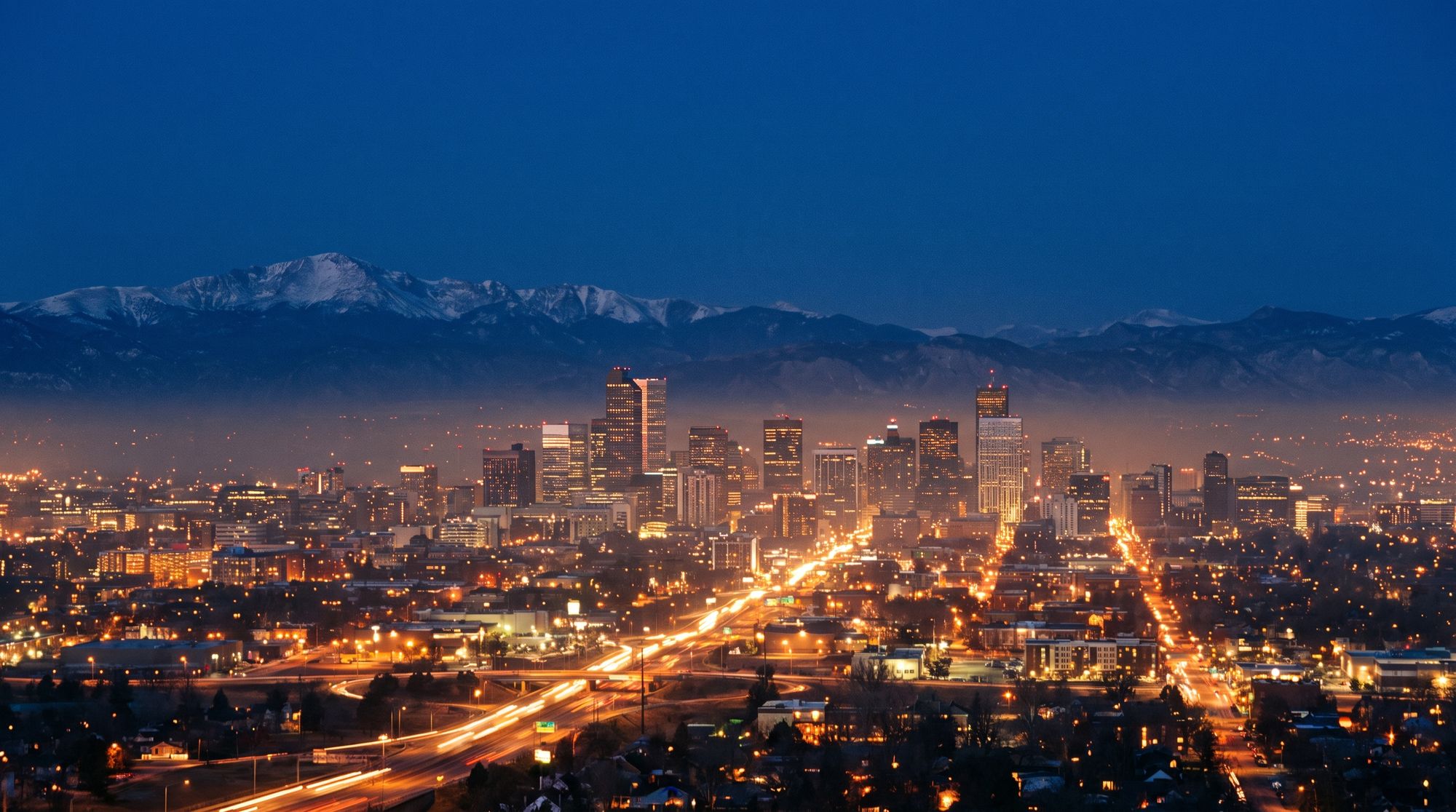 Denver skyline with the Rocky Mountains at blue hour